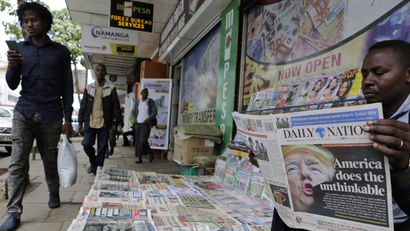 epa05625379 A Kenyan newspaper vendor (R) reads a newspaper featuring front page article about US President-elect Donald Trump as he waits for customers at a street in Nairobi, Kenya, 10 November 2016. Americans on 08 November chose Republican candidate Donald Trump as the 45th President of the United States of America, to serve from 2017 through 2020.
