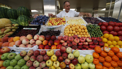 A vendor sells vegetables and fruits at the city market in St. Petersburg.