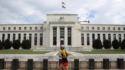 A jogger runs past the Federal Reserve building in Washington, DC