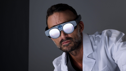 A person dressed in medical attire wears the Magic Leap 2 augmented reality headset