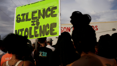 At a rally after El Paso shooting on August 5, a sign is held aloft reading "silence is violence."