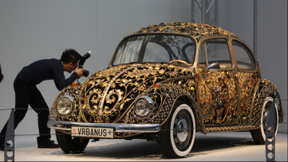 A visitor takes a picture at a modified Volkswagen VW Beetle during a press presentation prior to the Essen Motor Show in Essen November 30, 2012.