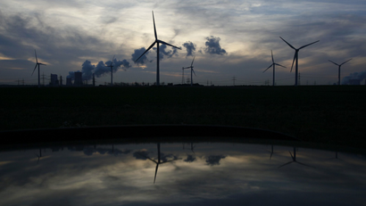 Wind generators and the Niederaussem coal power plant of RWE Power, one of Europe's biggest electricity and gas companies, are reflected in the roof of a car in Rheidt, north-west of Cologne .
