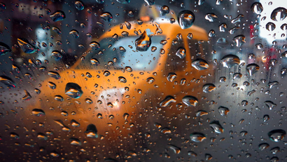 A taxi is pictured through the window of another taxi in the rain in Times Square in New York February 5, 2014. The latest in a series of winter storms hit the United States on Wednesday, threatening to drop up to a foot of snow in central New England, snarling travel and eating into supplies of salt needed to keep roads clear.