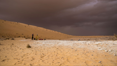 A person standing in the Nefud desert in Saudi Arabia.