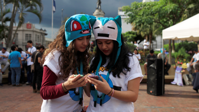 People play the augmented reality mobile game "Pokemon Go" by Nintendo on their mobile phone during a pokeour organized by the municipality in San Salvador