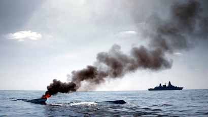 The German Frigate 'Hamburg' (R) patrols after destroying two fishing boats (L) which were discovered floating keel side up in open waters off the coast of Somalia, in this undated handout photo made available to Reuters August 15, 2011. Since November 2010, the German Frigate 'Hamburg' has been part of the European Union Naval Force (EUNAVFOR) Somalia ? Operation Atalanta. Operation Atalanta's main tasks are to escort merchant vessels carrying humanitarian aid of the World Food Program (WFP) and vessels of African Union Mission in Somalia (AMISOM). EUNAVFOR also protects vulnerable vessels in the Gulf of Aden and Indian Ocean, deters and disrupts piracy. The captain of Frigate 'Hamburg' decided to scupper the boats to stop them falling into the hands of pirates.