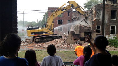 Demolition crews start tearing down four vacant apartment buildings in southwest Detroit, Thursday, July 19, 2012. The buildings, earlier gutted by fire, are among nearly 160 in the area targeted for demolition and were identified with help from community residents.