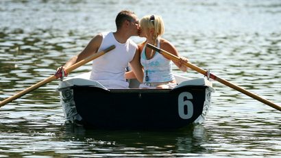 A couple enjoy a day out on the Serpentine boating lake in London