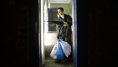 Jesus Pardal, an unemployed 29-year-old father-to-be, pushes buttons in an elevator holding garbage bags containing other people's trash to take out to earn 0.50 euro cents (0.60 US cents) in Cadiz, southern Spain November 2, 2012. Spain's number of jobless rose by 2.7 percent in October from a month earlier, or by 128,242 people, leaving 4.8 million people out of work, data from the Labour Ministry showed on Monday. This was the third straight month the jobless figures rose after a respite during the summer tourism season. Picture taken November 2, 2012. REUTERS/Marcelo del Pozo (SPAIN - Tags: BUSINESS EMPLOYMENT SOCIETY POVERTY TPX IMAGES OF THE DAY)