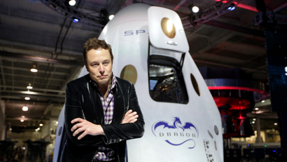 Elon Musk, CEO and CTO of SpaceX, listens to a question from the media in front of the SpaceX Dragon V2 spaceship at the headquarters on Thursday, May 29, 2014, in Hawthorne, Calif. SpaceX, which has flown unmanned cargo capsules to the International Space Station, unveiled the new spacecraft Thursday designed to ferry astronauts to low-Earth orbit. )