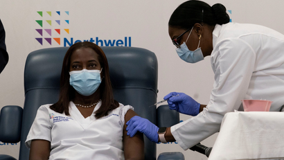 Sandra Lindsay, a nurse at Long Island Jewish Medical Center, is inoculated with the coronavirus disease (COVID-19) vaccine by Dr. Michelle Chester from Northwell Health at Long Island Jewish Medical Center in New Hyde Park, New York