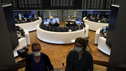 Women wear face masks at Frankfurt's stock exchange as markets.