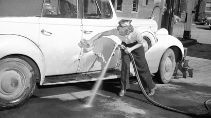 Labor shortage in Portland has caused women to take over certain jobs previously held by men. Gertrude Rutter is now a car-washer at a local gasoline station in Portland, Oregon, April 3, 1942. (AP Photo)