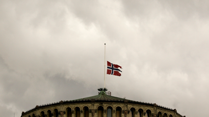 The Norwegian flag flutters at half-mast on the roof of the parliament building in Oslo July 23, 2011. Norwegian police searched for more victims on Saturday after a suspected right-wing zealot killed at least 92 people in a shooting spree and bomb attack that have traumatised a once-placid country. REUTERS/Wolfgang Rattay (NORWAY - Tags: CIVIL UNREST CRIME LAW IMAGES OF THE DAY) - RTR2P73Q