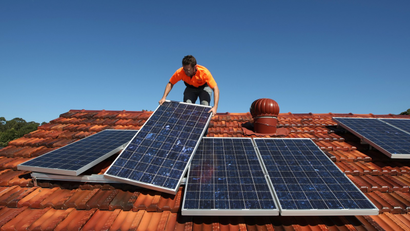 Solar system installer Thomas Bywater adjusts new solar panels.