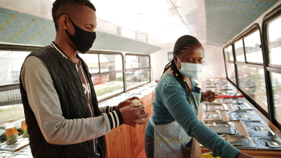 Sanele Msibi assists a customer inside the Skhaftin bus in Johannesburg, South Africa