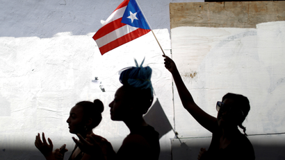 A woman waves a Puerto Rican flag during ongoing protests calling for the resignation of Governor Ricardo Rossello in San Juan
