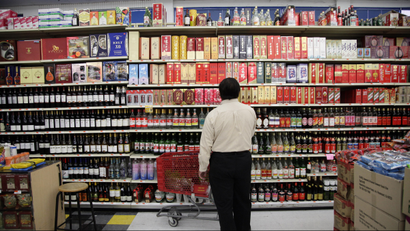 In this April 10, 2012, photo, a shopper looks at the section of imported hard liquor at a Chinese market in Monterey Park, Calif. When Walmart announced plans to put one of its sprawling outlets in Chinatown, alarms were quickly sounded by people fearful that a chain superstore would destroy the character of one of the nation's oldest, largest and most historic Chinatowns. These days New Chinatown, as it was called then, finds itself increasingly surrounded by multi-ethnic neighborhoods and high-density residential developments like the building that would house the Walmart store on its ground floor. (AP Photo/Jae C. Hong