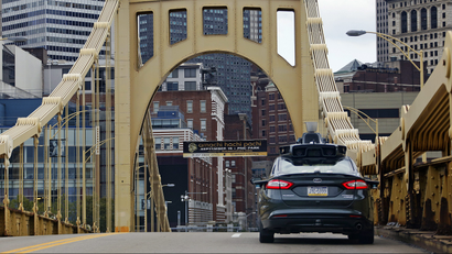 A self driving Uber car drives across the ninth street bridge in downtown Pittsburgh.