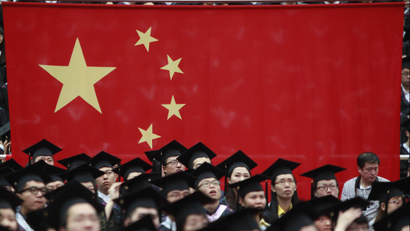 Graduates set next to the Chinese flag during a graduation ceremony at Fudan University in Shanghai June 28, 2013. A record high of 6.99 million students are expected to graduate from college this year which places severe pressure on their search for jobs, according to Xinhua News Agency. REUTERS/Aly Song
