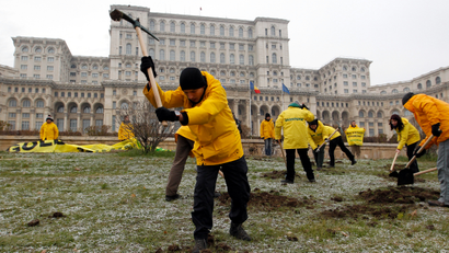 Greenpeace activists dig into the yard of Romania's Parliament, to protest against a Canadian company's plan to set up Europe's biggest open-cast gold mine in Romania, in Bucharest December 9, 2013. A special Romanian parliament commission overwhelmingly rejected a draft bill that would have allowed Canada's Gabriel Resources to set up Europe's biggest open-cast gold mine in the small Carpathian town of Rosia Montana last month. However, parliament plans to revise a mining law that could open way for the project.