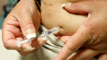 A woman injects herself with insulin
