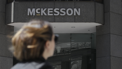 A pedestrian passes a McKesson sign on an office building.