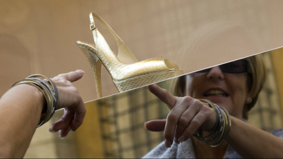 woman pointing at Jimmy Choo shoe in a window