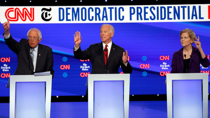 Democratic presidential candidate Sen. Bernie Sanders, I-Vt., left, former Vice President Joe Biden, center, and Sen. Elizabeth Warren, D-Mass., raise their hands to speak.