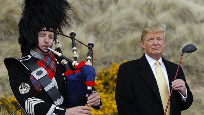 U.S. property mogul Donald Trump (R) stands next to a bagpiper.