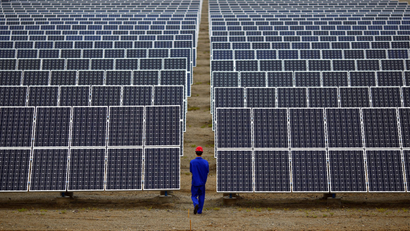 A worker inspects solar panels at a solar Dunhuang, 950km (590 miles) northwest of Lanzhou, Gansu Province September 16, 2013.
