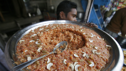 A worker carries gaajar ka halwa, a sweet dish made from carrots and milk, to a shop at Noida in the northern Indian state of Uttar Pradesh, December 23, 2010. India's food price index rose 12.13 percent in the year to December 11, government data on Thursday showed.