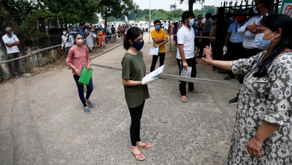 Students wearing protective face masks arrive at an examination centre for National Eligibility cum Entrance Test (NEET), amidst the spread of the coronavirus disease (COVID-19), in Ahmedabad, India