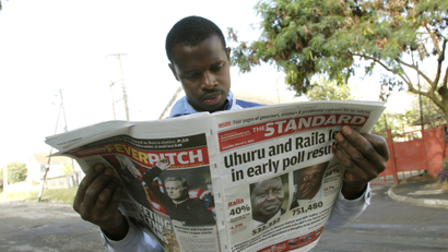 A Kenyan looks at a newspaper a day after the country's presidential election, at a roadside stall in Nairobi, Kenya Tuesday, March 5, 2013. Kenya's presidential election drew millions of eager voters who endured long lines to cast ballots Monday, but the vote was marred by violence that left 19 people dead, including four policemen hacked to death by machete-wielding separatists.