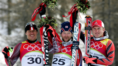 Kjetil Andre Aamodt (C) of Norway, Ambrosi Hoffmann (R) of Switzerland and Hermann Maier of Austria hold flowers as they stand on the podium after the men's Alpine skiing super-G at the 2006 Torino Winter Olympic Games in Sestriere, Italy February 18, 2006.
