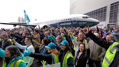 Boeing workers pose in front of a Boeing 737 MAX 7, the newest version of Boeing's fastest-selling airplane, for a group photo during a debut for employees and media of the new jet Monday, Feb. 5, 2018, in Renton, Wash. The company says that the airplane improves on the design of its predecessor, the 737-700, with more capability, range and seats. Following upcoming flight tests, it is expected to be delivered to airline customers beginning in 2019.