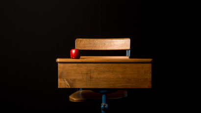 A classroom desk with black background