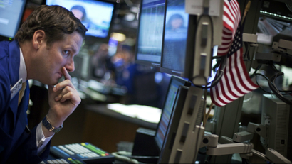 A trader looks at his screens while working on the floor of the New York Stock Exchange.
