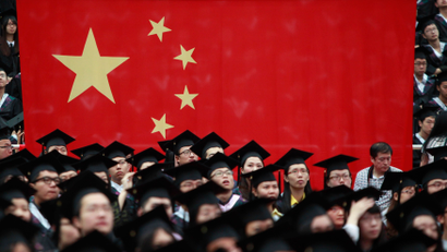 Graduates set next to the Chinese flag during a graduation ceremony at Fudan University in Shanghai June 28, 2013.