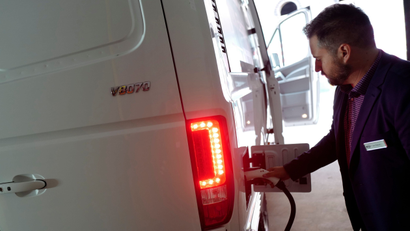 Ian Televise, the head of marketing for Chanje, demonstrates the re-charging port on the company's V8070 electric medium-duty truck, Thursday, Nov. 2, 2017, in New York. The vehicle can carry a load of up to 6,000 pounds for a distance of about 100 miles on a single charge. Truck rental company Ryder Systems Inc. is adding 125 of the fully electric vans to its fleet. (AP Photo/Mark Lennihan)
