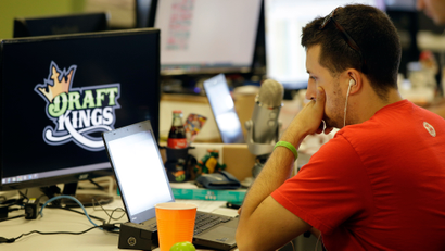 FILE - In this Sept. 9, 2015 file photo, Devlin D'Zmura, a tending news manager at DraftKings, a daily fantasy sports company, works on his laptop at the company's offices in Boston. Customers of the two biggest daily fantasy sports websites have filed at least four lawsuits against the sites in Oct. 2015, following cheating allegations and a probe into the largely-unregulated multi-billion dollar industry. In court papers, the customers accused the DraftKings and FanDuel sites of cheating, and argued they never would have played had they known employees with insider knowledge were playing on rival sites. (AP Photo/Stephan Savoia)