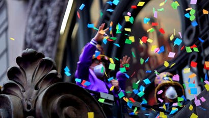 People in masks toss confetti into the air to test New Year's Eve decor.