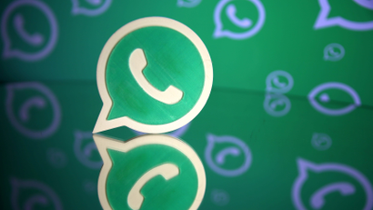A 3D printed Whatsapp logo is seen in front of a displayed Whatsapp logo in this illustration