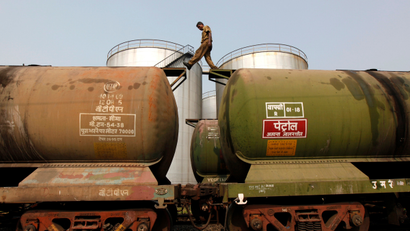 A worker walks atop a tanker wagon to check the freight level at an oil terminal on the outskirts of Kolkata November 27, 2013. An Indian delegation will shortly visit Iran to discuss the oil payment mechanism, and will include representatives from the oil ministry, oil companies, refiners and the finance ministry, oil secretary Vivek Rae said on Wednesday. Iran and six world powers reached a deal on Sunday to curb Tehran's nuclear programme in exchange for limited relief from sanctions imposed by the U.S. and European Union (EU) that have slashed Tehran's oil exports.