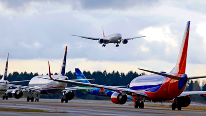 One passenger jet comes in for a landing and in view of a line of planes waiting to takeoff, Wednesday, Dec. 16, 2015, at Seattle-Tacoma International Airport, in SeaTac, Wash. Boeing Co., Alaska Airlines and the Port of Seattle announced Wednesday that they are partnering on a $250,000 study to explore how to bring more aviation biofuel to airplanes at Seattle-Tacoma International Airport. Executives for the companies and port signed an agreement, saying the study will help stimulate production of alternatives to conventional jet fuel. They say the longer term plan is to incorporate more biofuel into the airport’s fuel farm, which is used by all 26 airlines.