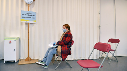 A woman sits alone at a vaccination site