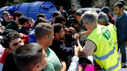 Migrants receive meals from members of refugee aid organisations during the distribution of food at the makeshift camp called "The New Jungle" in Calais, France, September 20, 2015. Around 3,500 migrants and refugees are camped in Calais, fleeing war and poverty in the Middle East, Africa and Asia and now living in the jungle. Most of them are hoping to make the crossing to England. Picture taken September 20, 2015.