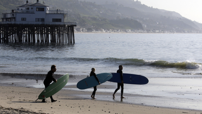 Surfers head for the waves at about the time the effects of a tsunami were expected, at Surfrider Beach in Malibu, Calif., Friday, March 11, 2011.