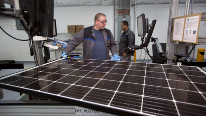 Production operator John White checks a panel at the SolarWorld solar panel factory in Hillsboro